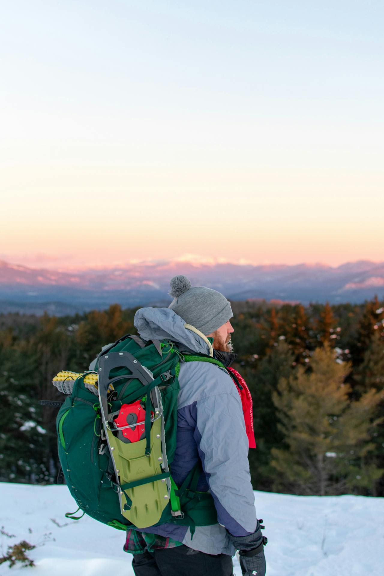 man wearing backpack in the forest snow