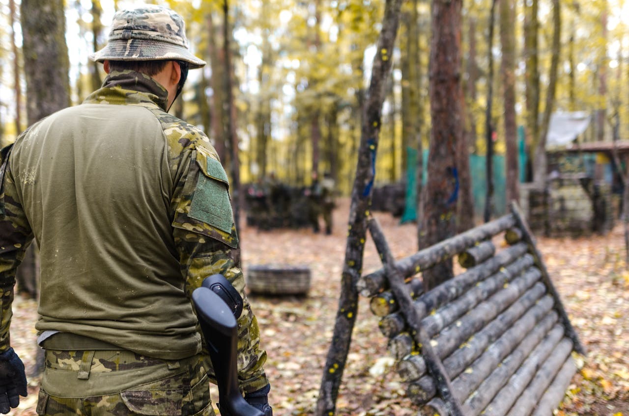 man in camo clothing in the woods