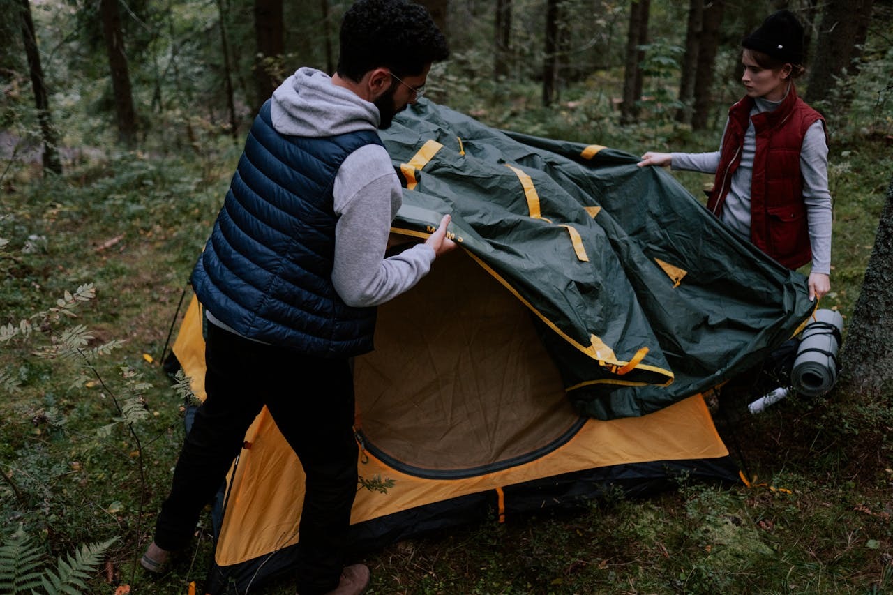A man and a woman setting up a tent