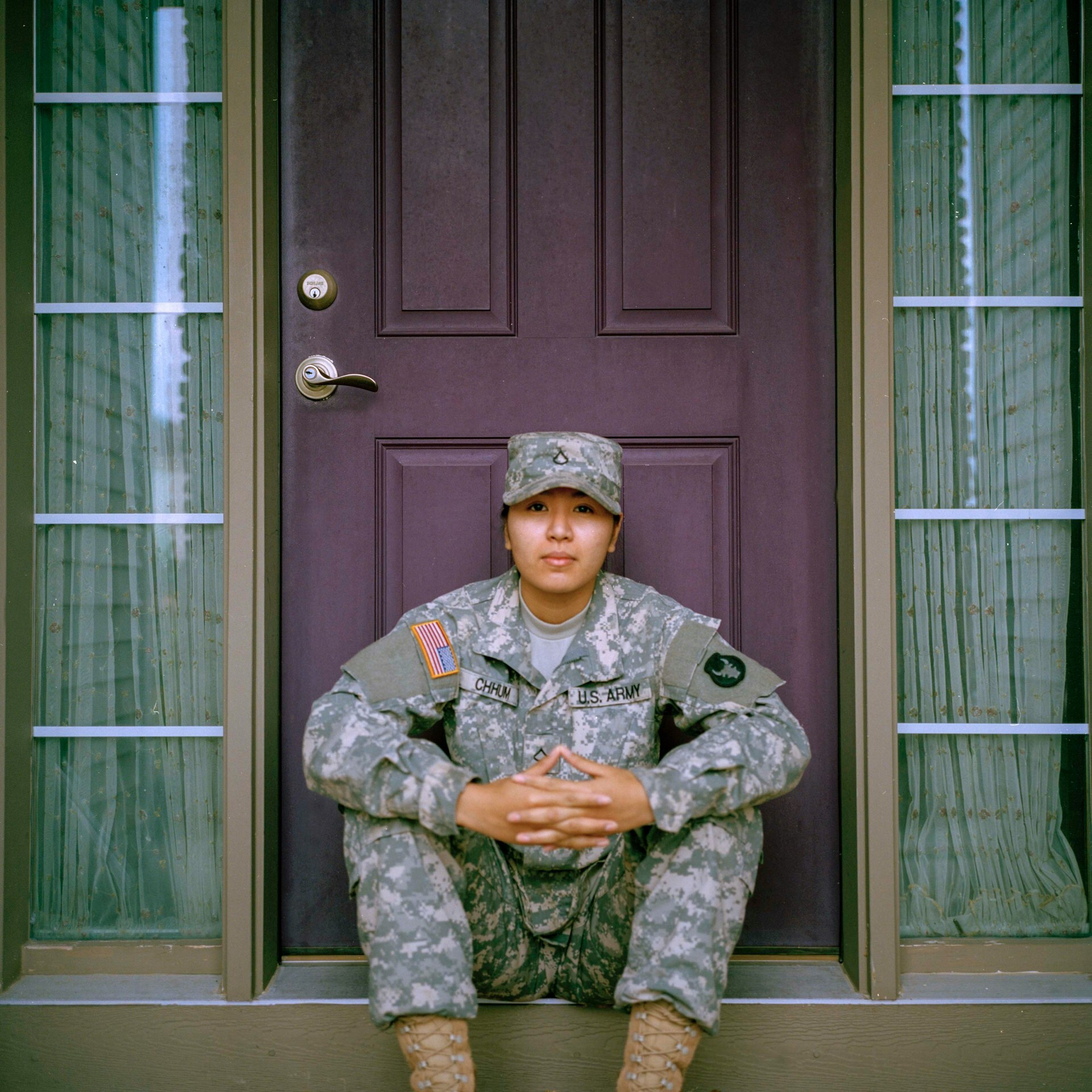 soldier in uniform and patrol cap sitting in front of door